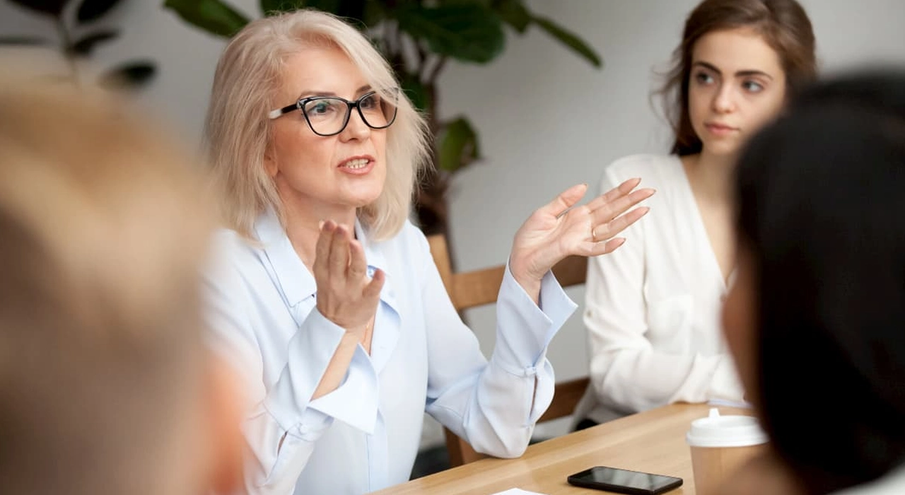 Successful women in a meeting discussing ideas, highlighting trend of women on bio boards transitioning to CEO roles