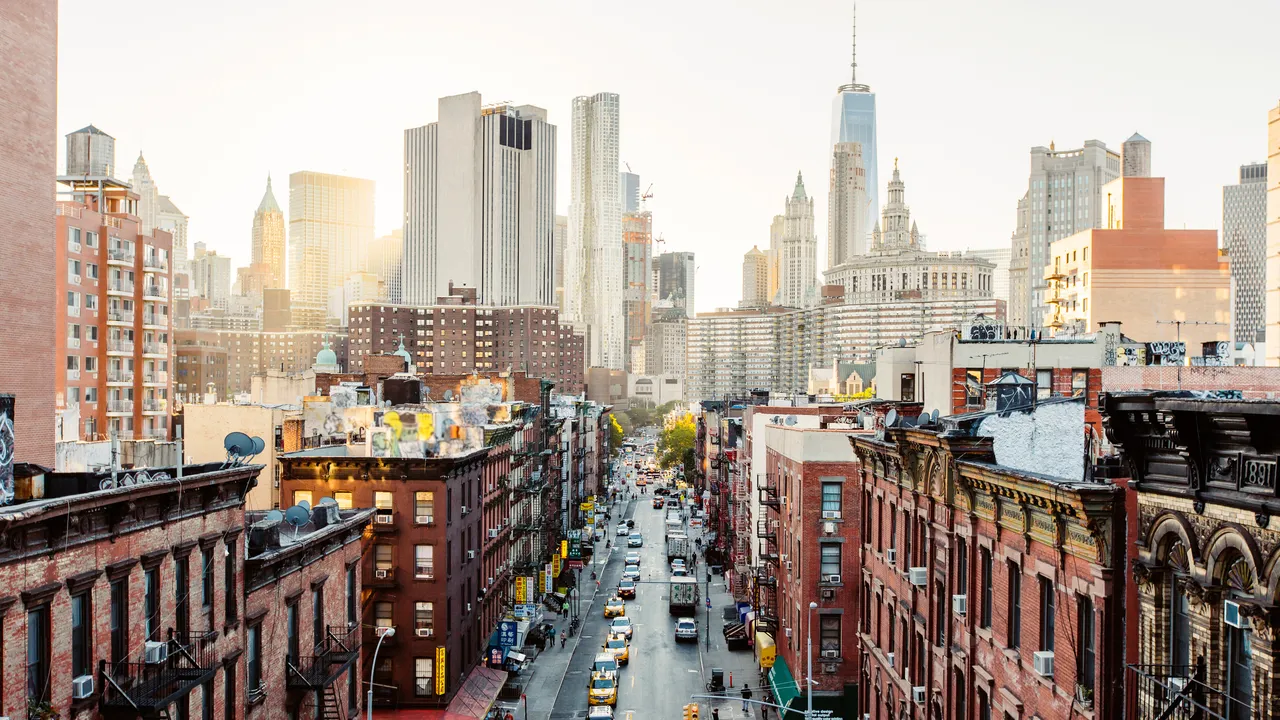 Panoramic view of New York City skyline featuring iconic skyscrapers and urban architecture at sunset