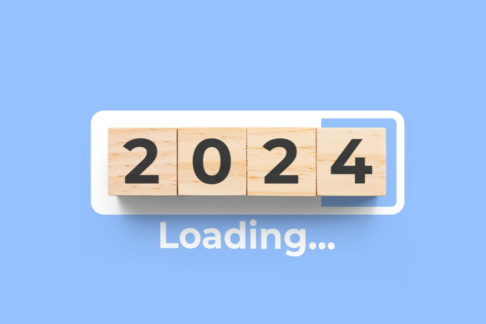 Stack of natural wooden cubes with 2024 engraved, arranged on a blue background